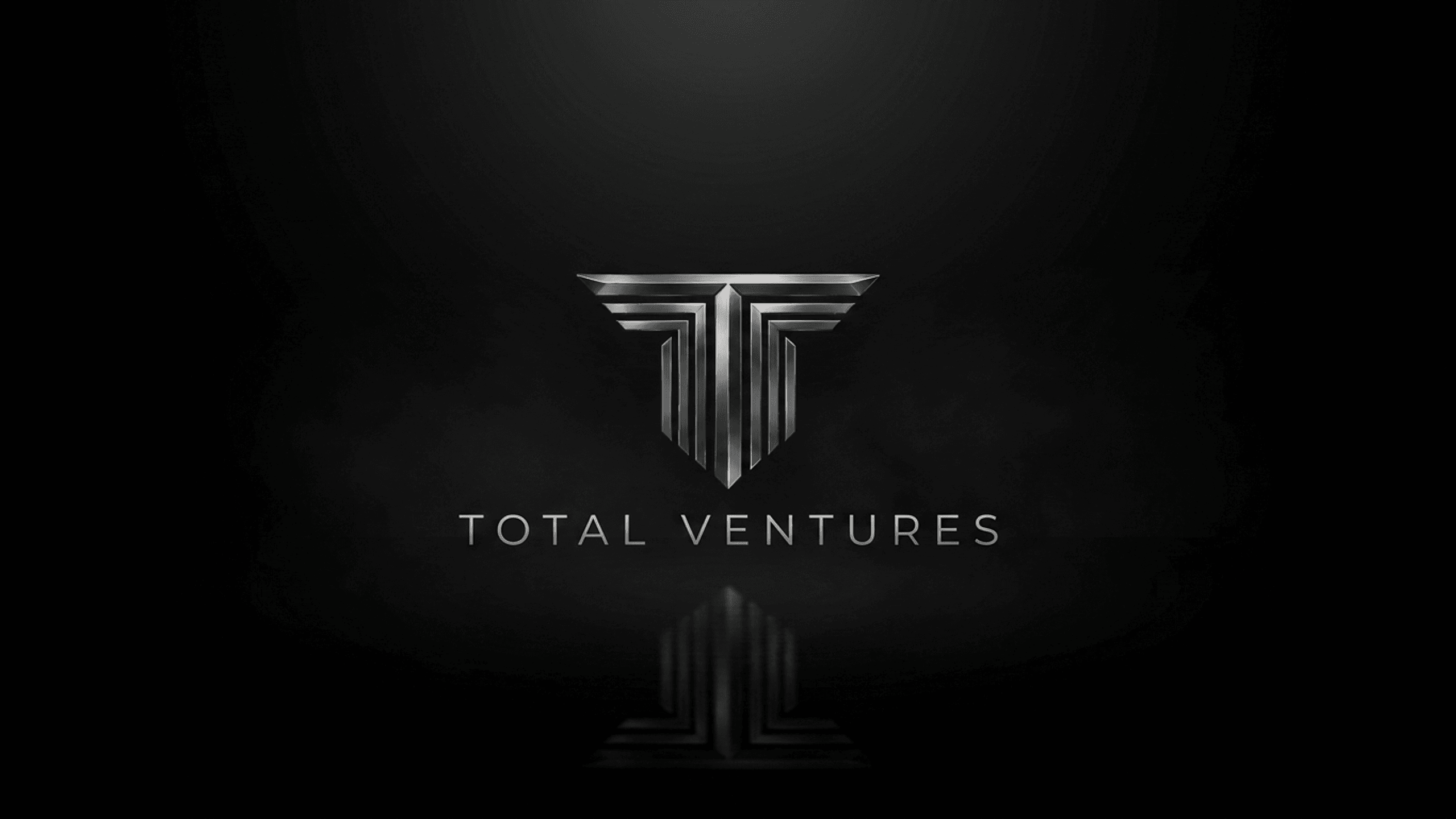 Total Ventures — the metallic winged double-T monogram on a cinematic near-black void, with the TOTAL VENTURES wordmark.